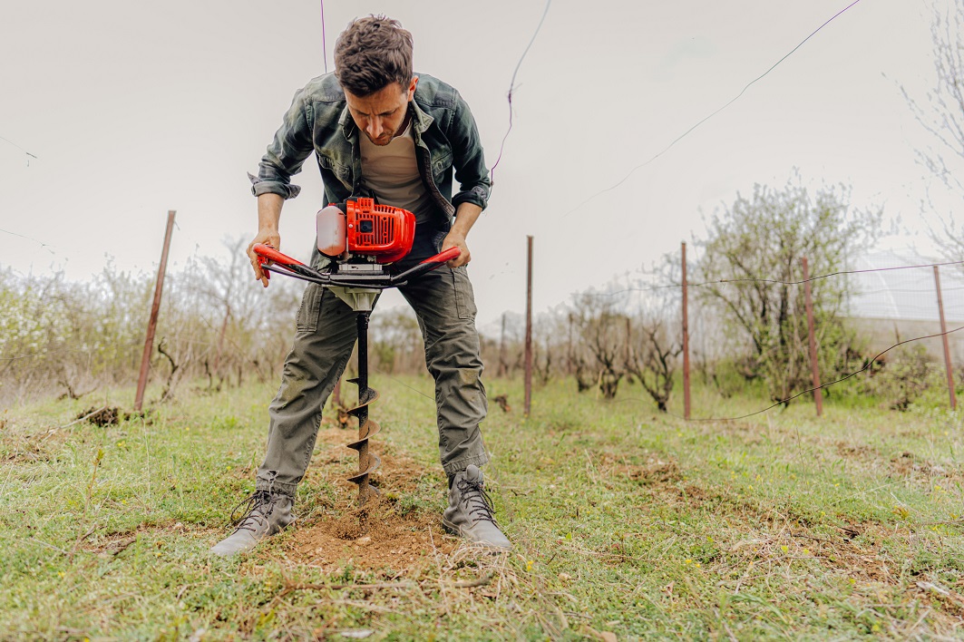 mężczyzna wierci w ziemi